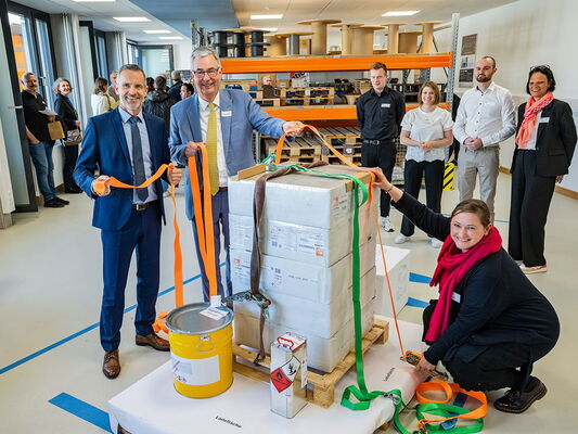 Schulleiter Oliver Schmider und Landrat Dietmar Allgaier sichern symbolisch eine Palette im neuen Übungslager der Erich-Bracher-Schule.