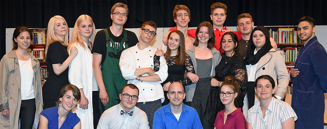Gruppenfoto der Theater-AG der Erich-Bracher-Schule nach der Aufführung. Die Schülerinnen und Schüler tragen unterschiedliche Kostüme.