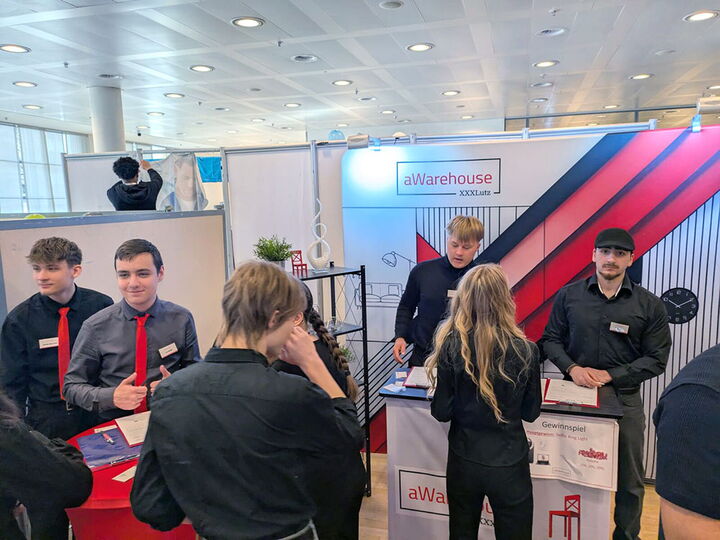 Schülerinnen und Schüler der Übungsfirma aWarehouse XXXLutz bereiten ihren Stand auf die Übungsfirmenmesse vor.