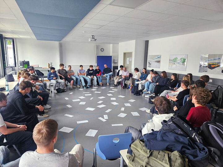 Schüler der Erich-Bracher-Schule tauschen sich in einem Stuhlkreis mit den Referenten von Meet a Jew über jüdisches Leben in Deutschland aus.