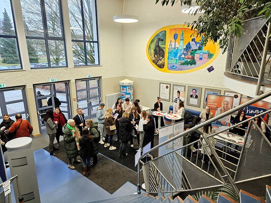 Besucher beim Tag der offenen Tür im Foyer der Erich-Bracher-Schule an verschiedenen Infoständen.